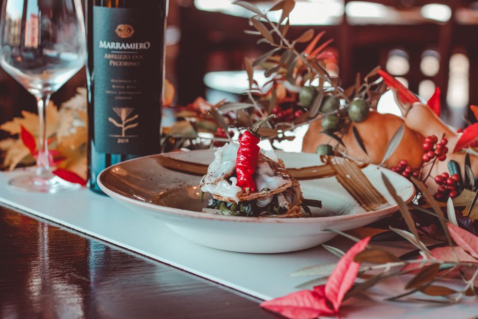 Cheffe Olivia Marchand en cuisine, composant une assiette raffinée de saison